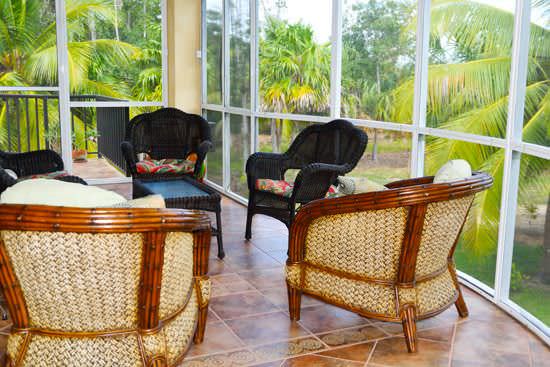 Rounded screened veranda with rotan armchairs